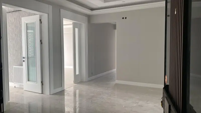 Beyaz kapılı, mermer zeminli hol